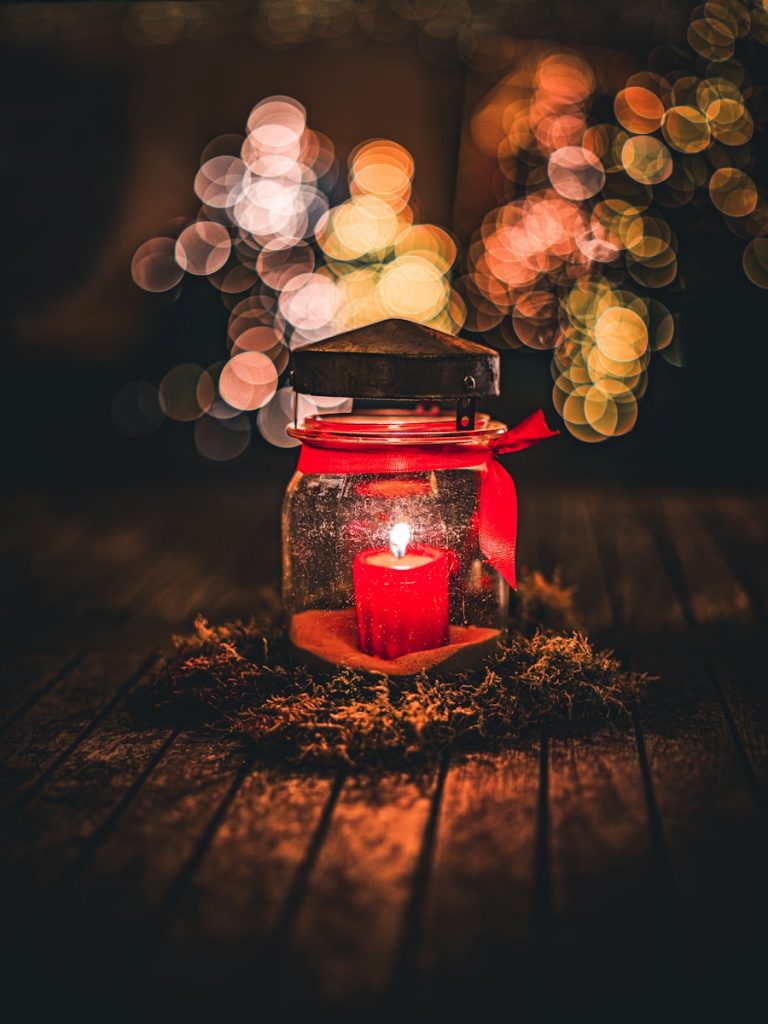 A red candle sitting on top of a wooden table